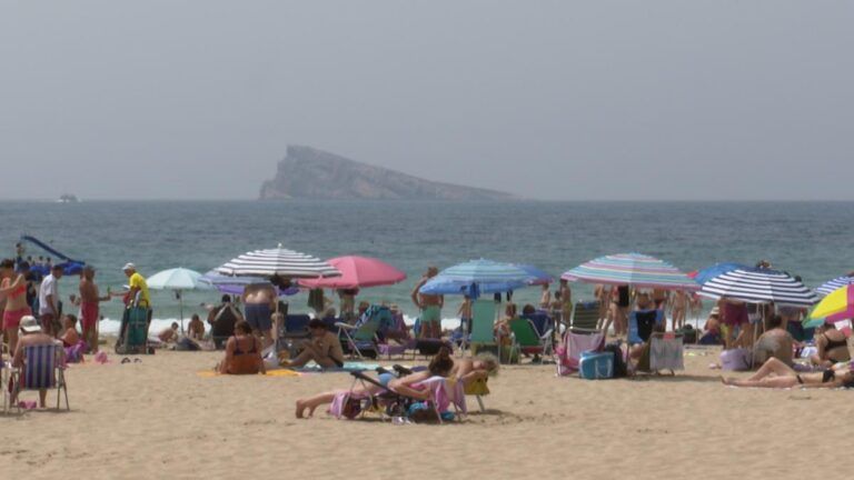 turistas se refrescan en la playa de benidorm en la ola de calor