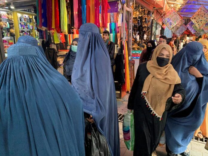 mujeres vestidas con burka y hiyab o panuelo islamico en un mercado de kabul