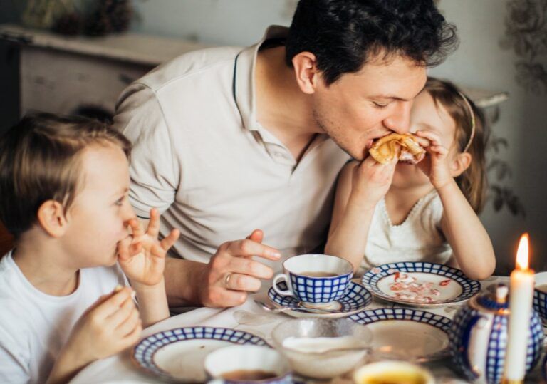 un padre desayunando junto a sus dos hijos