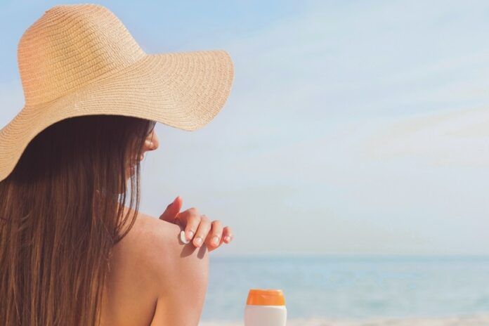 mujer tomando sol crema solar