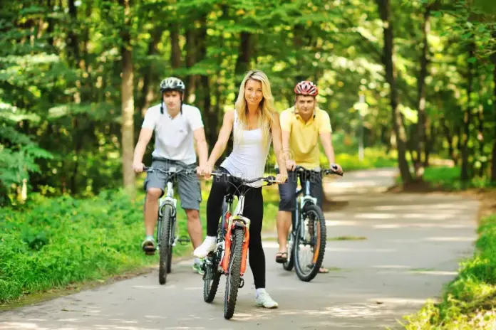 gente feliz atractiva en las bicicletas en el campo ciclistas