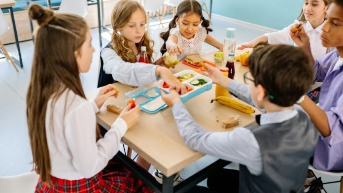 Niños en un aula disfrutando de frutas y leche en un programa de alimentación saludable escolar en Castilla La Mancha Niños en un aula disfrutando de frutas y leche en un programa de alimentación saludable escolar en Castilla La Mancha