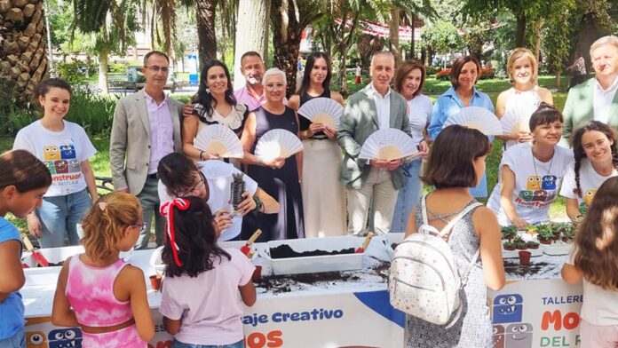 Niños participan en talleres de reciclaje creativo con botellas en el Paseo de San Gregorio durante las fiestas de Puertollano 2025